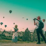 couple taking a photo watching hot air balloons traveling adventure