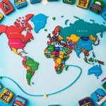 A colorful world map surrounded by iconic landmarks and symbols of different countries, with a winding path connecting them